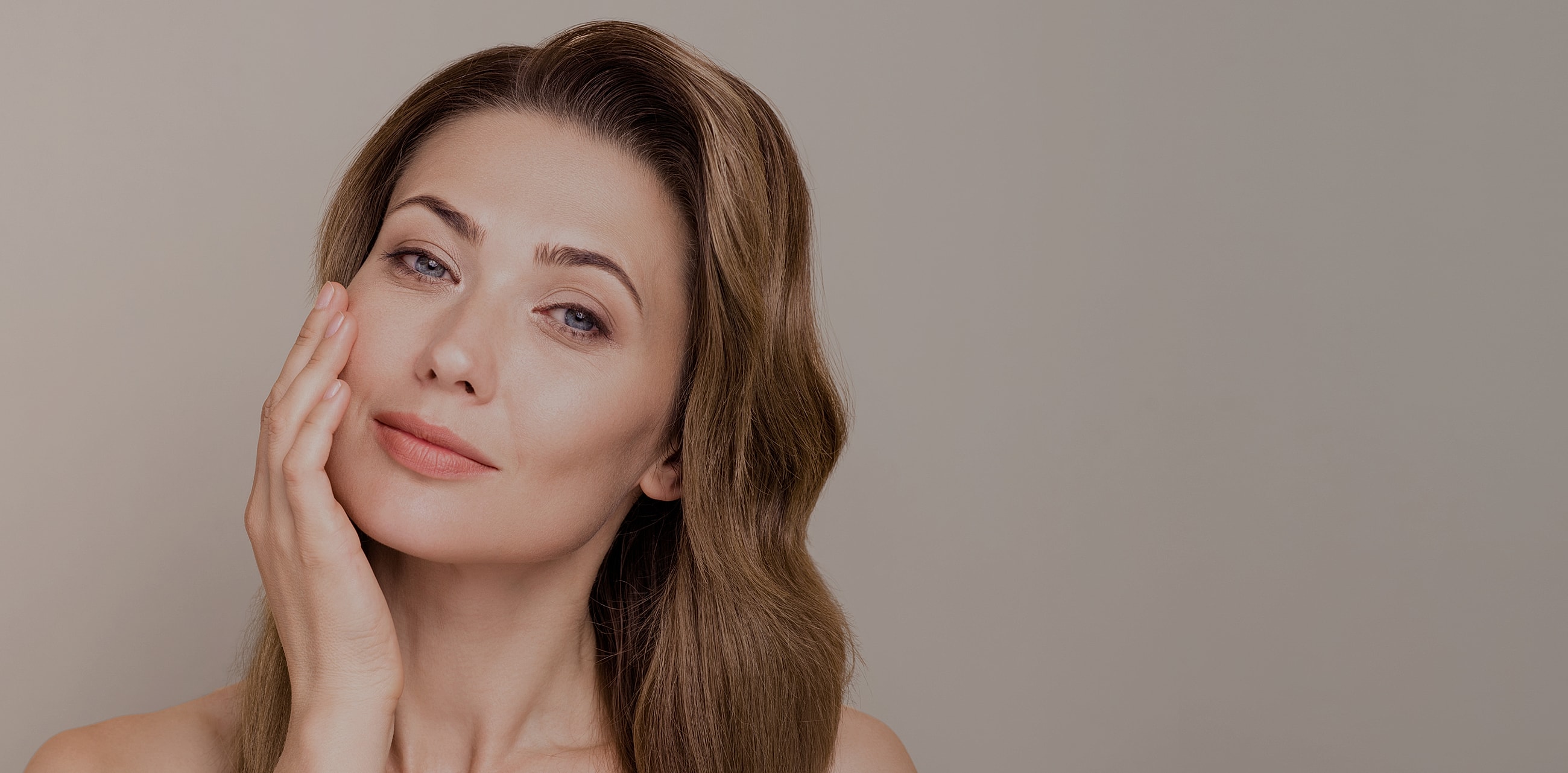 Woman touching her face with a serene expression.