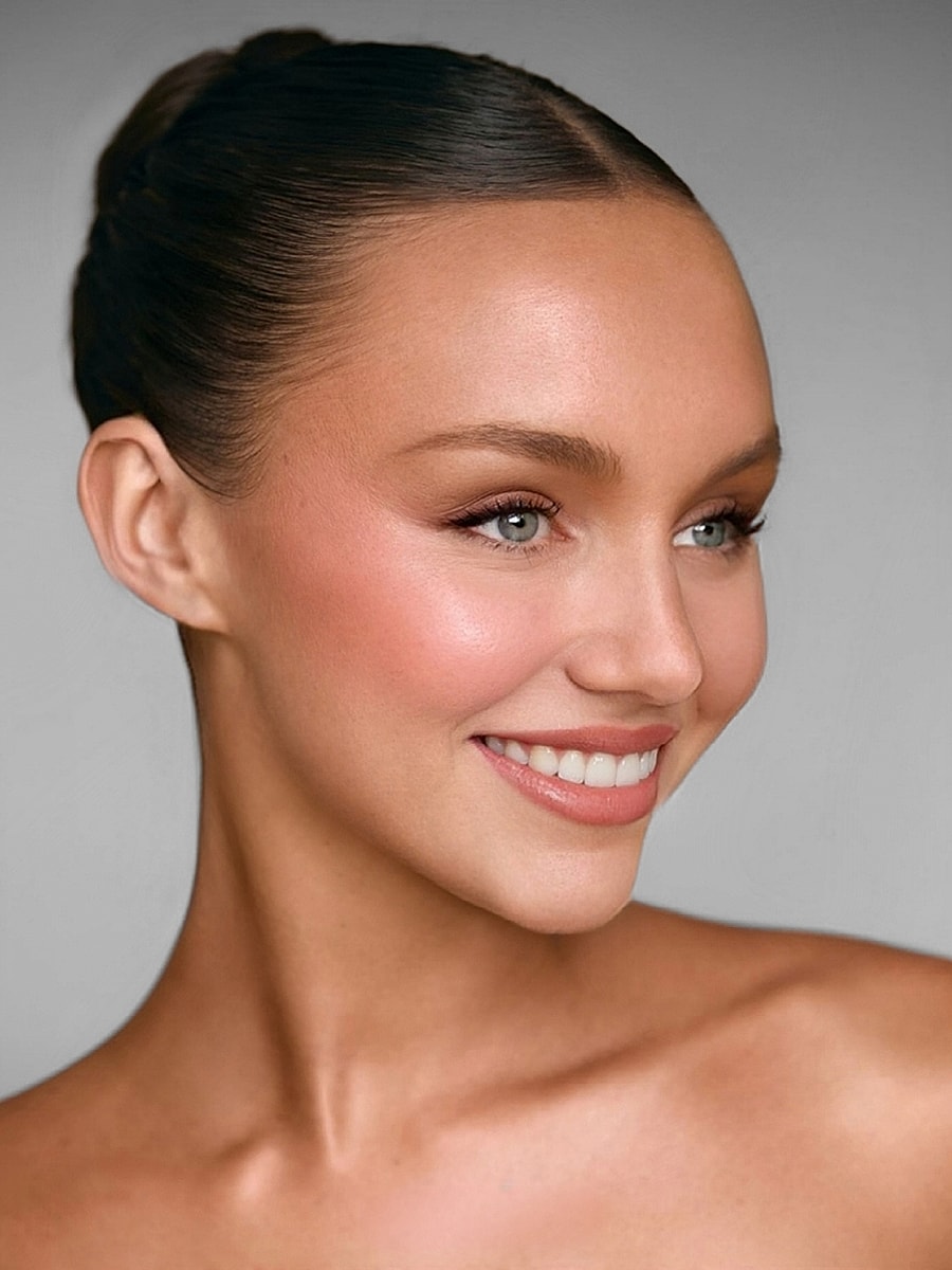 Smiling woman with elegant hairstyle and makeup.