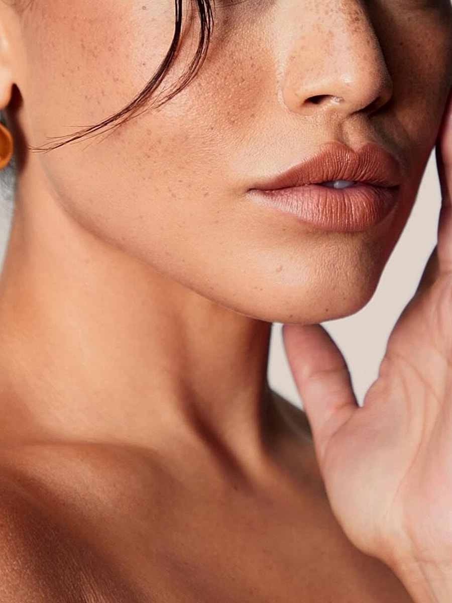 Close-up of a woman's face and hand.